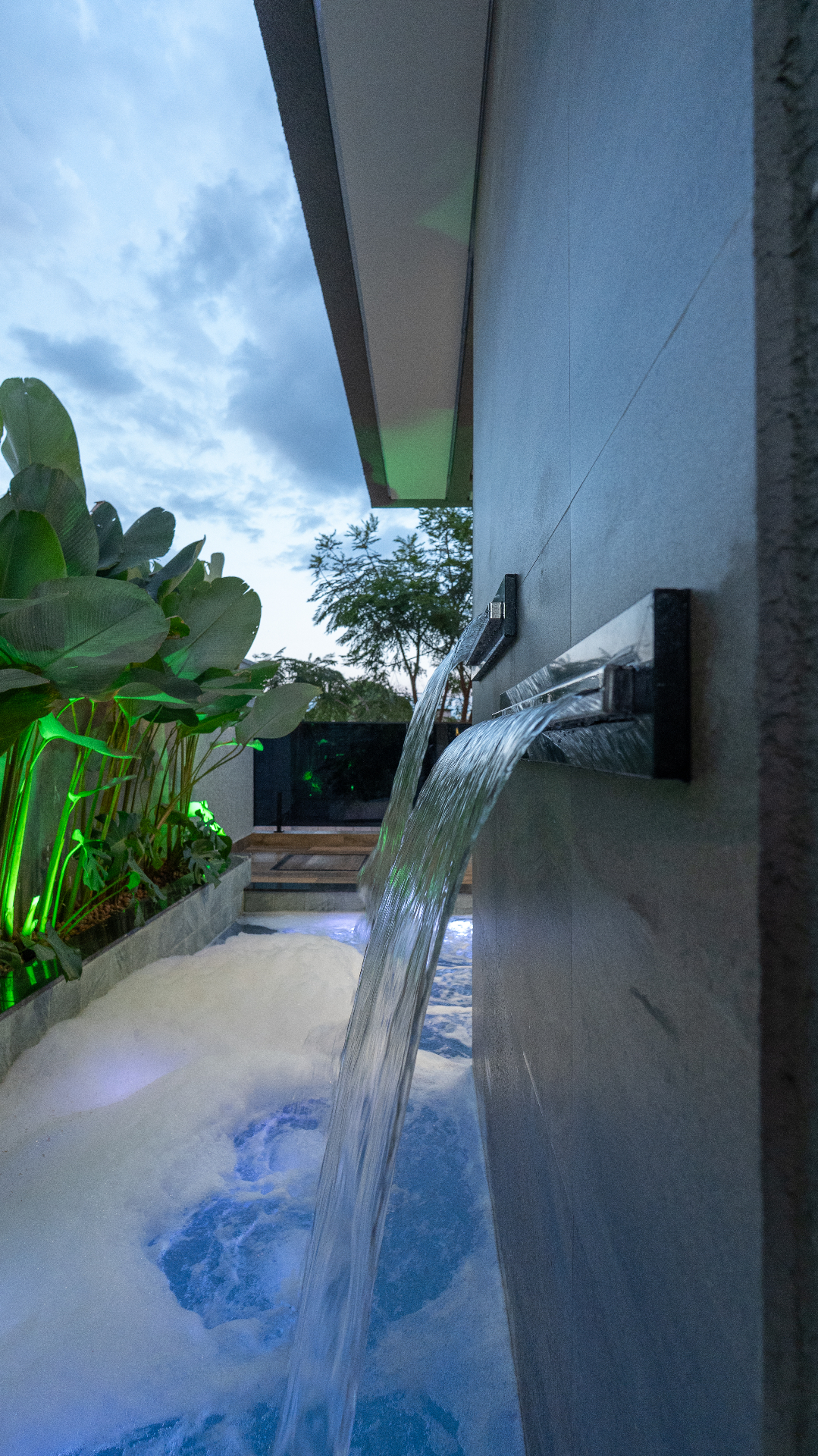 Área de lazer com cascata e iluminação cênica